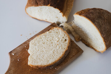 Freshly sliced homemade bread on a wooden cutting board in a simple kitchen setting