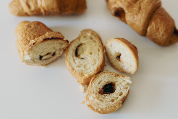 Freshly baked croissants and slices reveal rich filling on a bright kitchen counter during morning hours