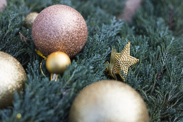 Golden ornaments and festive decorations on evergreen branches during the holiday season