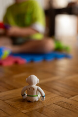 Child playing with colorful toys in a cozy indoor setting with a white robot figurine in the foreground during daytime