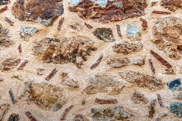 Close-up texture of a stone wall at Alanya Castle, Turkey. The stones vary in color and shape, highlighting the historic craftsmanship of the fortress