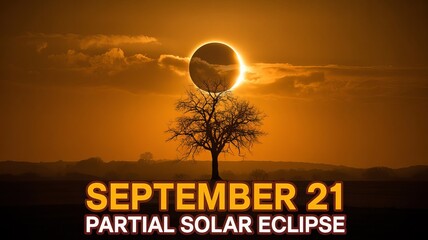 Dramatic solar eclipse on September 21st creates stunning silhouette against orange sky with lone tree