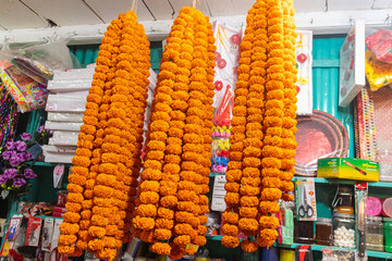 Vibrant orange marigold garlands hanging in local market shop.