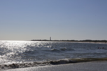A view of the Cape May lighthouse and shoreline from cove on a clear summer day.