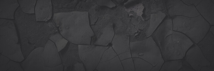 Dark wide panoramic background. Peeling paint on a concrete wall. Faded dark texture of old cracked...