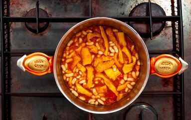 A classic Brazilian dish known as dobradinha, prepared with beef tripe, white beans, and tropical spices, served with traditional farofa made from toasted cassava flour.