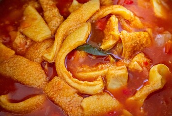 A classic Brazilian dish known as dobradinha, prepared with beef tripe, white beans, and tropical spices, served with traditional farofa made from toasted cassava flour.