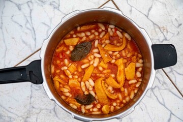 A classic Brazilian dish known as dobradinha, prepared with beef tripe, white beans, and tropical spices, served with traditional farofa made from toasted cassava flour.