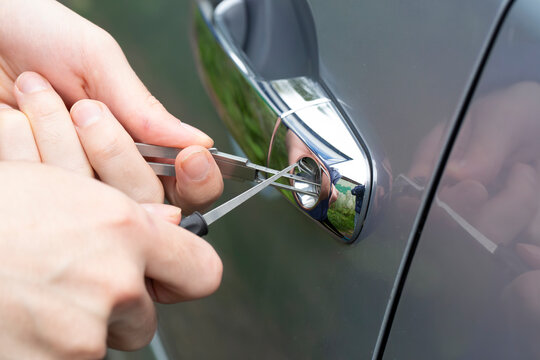 The hijacker tries to break into the car with a scanner. Code grabber . Car thief, car theft.