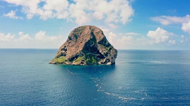 Slow approach of Diamond Rock island in Martinique, France. The uninhabited Diamond Rock is a 175m high basalt island located south of Grande Anse du Diamant.