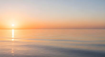 Obraz premium Serene ocean sunset with golden light reflecting on calm, rippling water, evoking peace and tranquility.