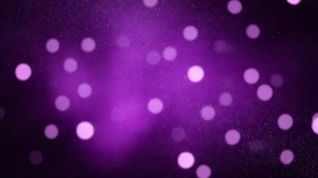 Blurred purple abstract background of bokeh and small round particles of energy magical holiday flying dots on a black background