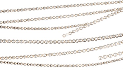 Diagonal Strings Of Gold And Pearl Beads Against A Transparent And White Background Emphasizing Bokeh Effect