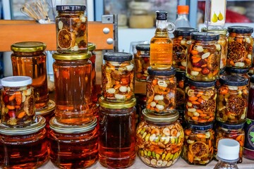 Close Display of Honey Jars with Nuts and Fruits at Farmers Market