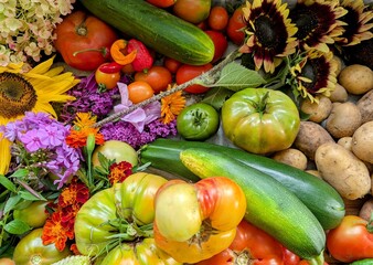 Flat lay of bountiful harvest with Carolina Reapers, heirloom tomatoes, and flowers