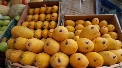 Fresh mangoes piled high in crates and wicker surface
