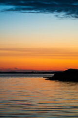 Obraz premium Tranquil seaside sunset over rocky coastline.