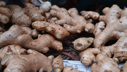 Irregular ginger roots piled, showing bumpy light brown texture