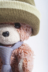 Cropped Close up of Old teddy bear with hat and tie