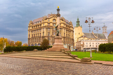 Obraz premium Adam Mickiewicz Monument in Lviv city center, Ukraine, with surrounding historic buildings and churches