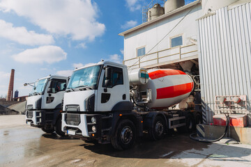 Concrete mixer trucks loading at production plant