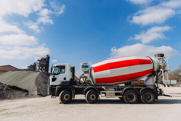 Concrete mixer truck parked at production plant on sunny day