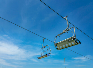 Two cable car seats with clear blue sky in the background