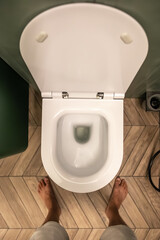 Fototapeta premium Person over toilet. Modern bathroom design. Top view