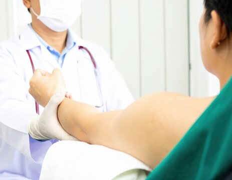 Clinical Examination Masked Physician Assesses Patients Arm from an OvertheShoulder View.
