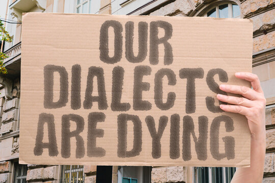 "Our dialects are dying" on a protest banner highlighting threats to linguistic heritage.
HERITAGE. IDENTITY. TRADITION. LANGUAGE. CULTURE. MINORITY. VOICES.