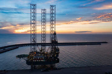 Aerial view of offshore jack up rig in a shipyard during sunset for oil and gas exploration and production.