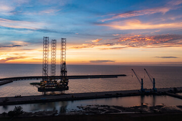 Aerial view of offshore jack up rig in a shipyard during sunset for oil and gas exploration and production.
