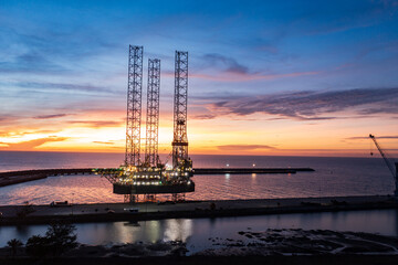 Aerial view of offshore jack up rig in a shipyard during sunset for oil and gas exploration and production.
