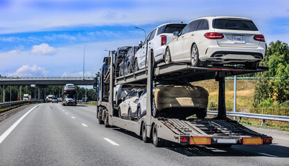 car transporter truck transports cars along a country road