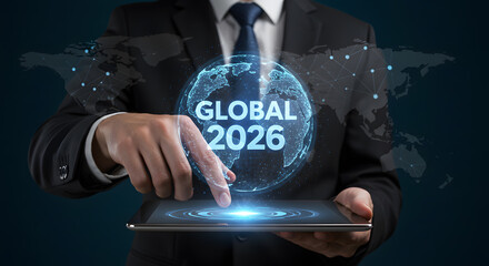 Businessman holding tablet with a hologram of globe showing global business strategy and international market development plan for the year 2026