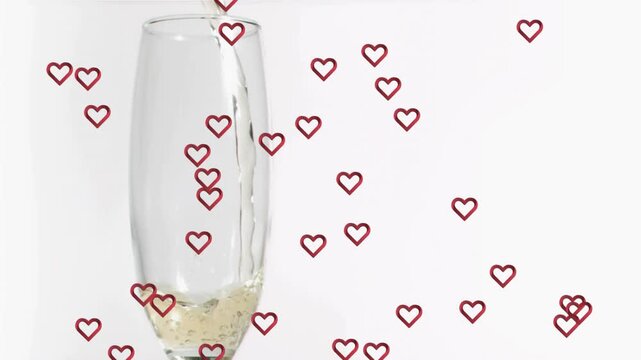 Wine stream entering champagne flute bubbles forming red hearts multiplying around glass for love