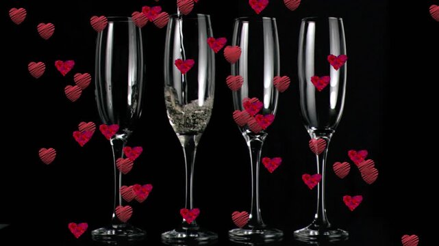 When champagne stream pouring into 2nd flute bubbles rising and hearts floating creating romance