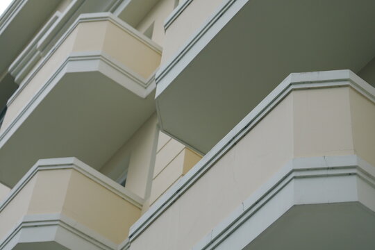 Abstract architectural background of a modern apartment building facade. Low angle view of geometric balconies creating lines and patterns.