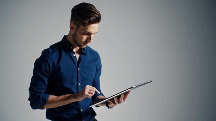 Attractive male utilizing electronic tablet full length portrait of youthful man in casual clothing using digital tablet vertical shot on white background - Powered by Adobe
