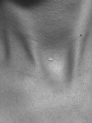 Fototapeta premium A drop of water on the body. Black and white photo of the neck. Body aesthetics. 