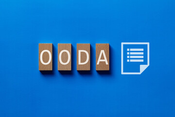 There is wood block with the word OODA. It is an abbreviation for Observe, Orient, Decide, Act as eye-catching image.