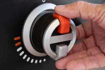 Close up of Man's Hand turning the Knob on a Gas Grill or Griddle