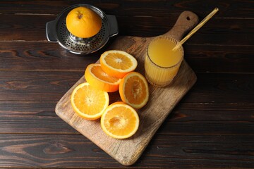 Freshly squeezed orange juice, fruits and juicer on wooden table, above view