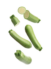Fresh ripe zucchinis falling on white background