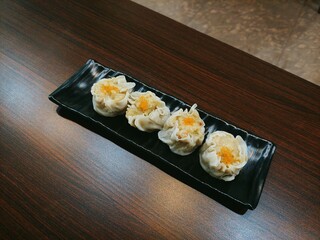 Dim Sum Delights: Steamed Dumplings on Black Plate