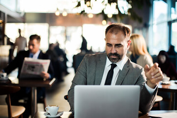 Businessman working on laptop in coffee shop
