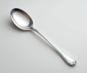 Polished silver spoon against a plain white background