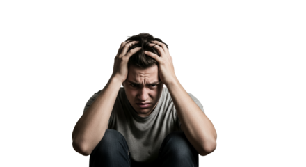 Isolated portrait of a young man clutching his head in despair against a stark white backdrop conveying intense frustration and emotional turmoil