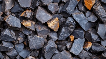 Pile of angular basalt stones with golden toned mineral deposits