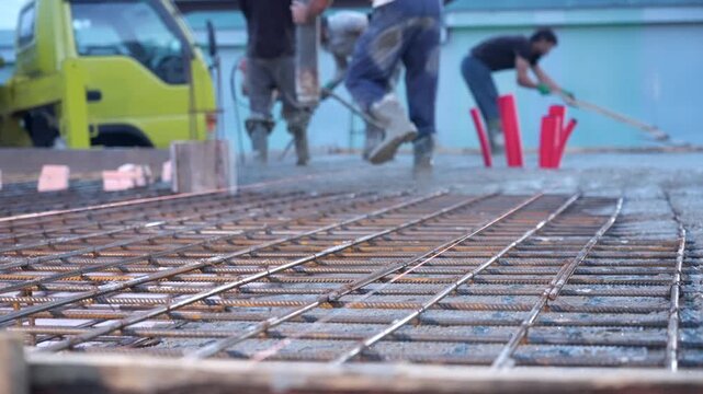 Pouring mixed concrete after installing steel reinforcement to create a house. 